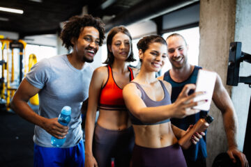 Group of sportive fit people in a gym taking selfie. Concepts about lifestyle and sport in a fitness club