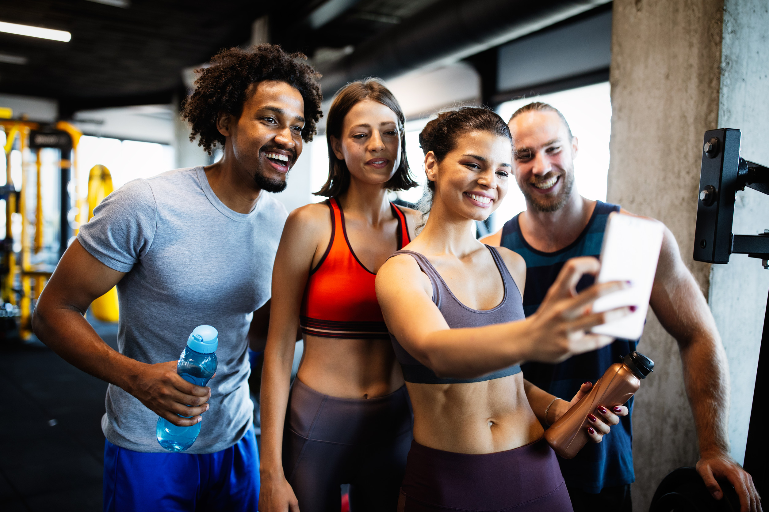 Group of sportive fit people in a gym taking selfie. Concepts about lifestyle and sport in a fitness club